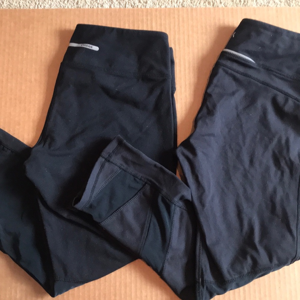 2 pairs of crop black leggings with sheer cutouts.